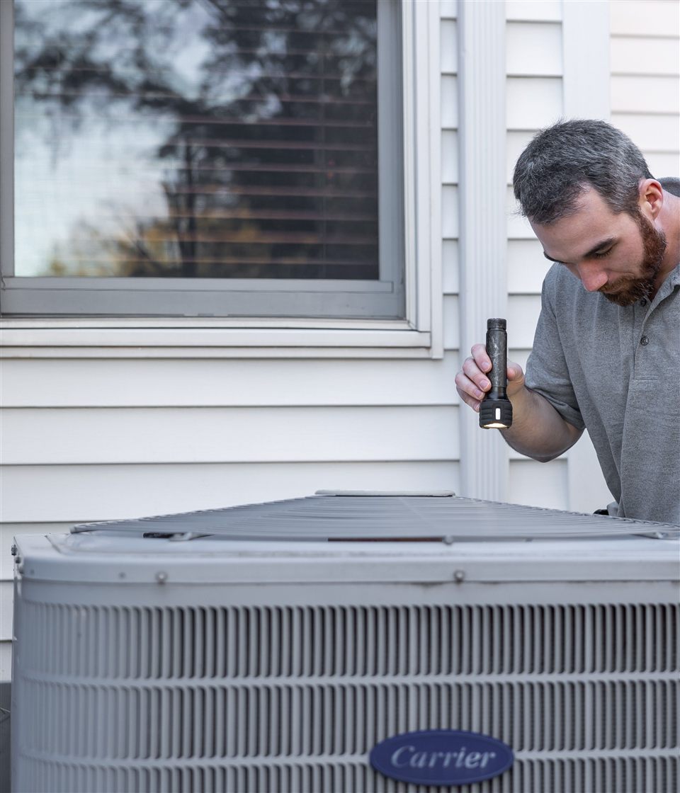 HVAC technician inspecting a residential air conditioning unit