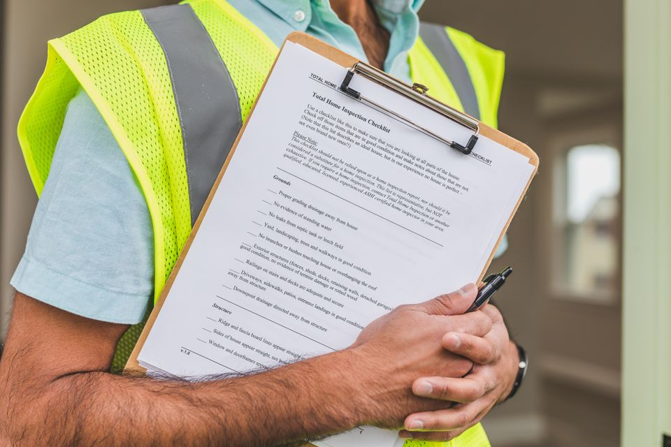 Inspector holding a maintenance checklist during a home service visit
