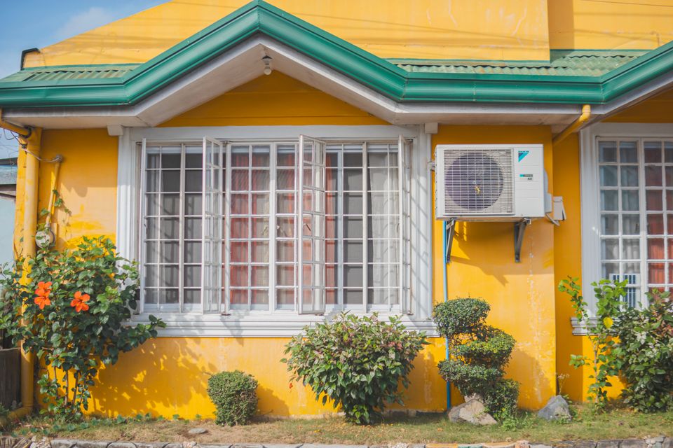 A residential home with a wall-mounted air conditioning unit